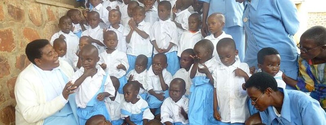 Eine Gruppe von Kindern in Uniformen und Betreuungspersonal im Waisenhaus in Burundi, einem Ort für Schutz, Bildung und Unterstützung.