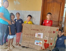 Kinder und Frau mit selbstgestaltetem Banner