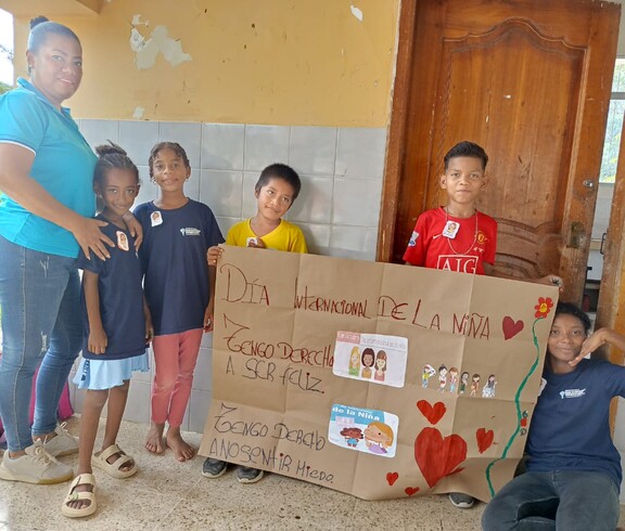 Kinder und Frau mit selbstgestaltetem Banner