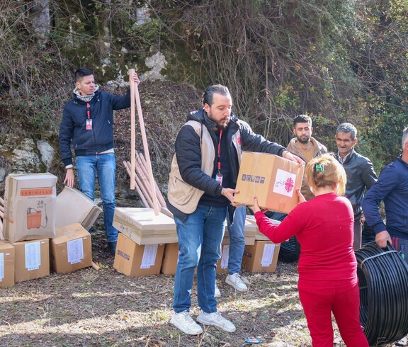 Caritas-Mitarbeiter übergeben Hilfspakete mit Agrargeräten und Saatgut an Familien in Latakia