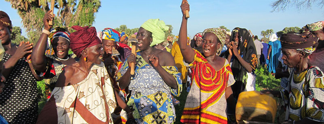 Sauberes Trinkwasser sichert das Überleben in Mali Frauen in Mali jubeln, während sie Werkzeuge hochhalten, um den erfolgreichen Zugang zu sauberem Trinkwasser und Unterstützung beim Obst- und Gemüseanbau zu feiern