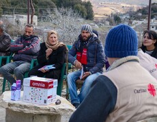 Caritas-Team diskutiert mit syrischen Landwirt*innen im Freien über Themen der Gemüseproduktion
