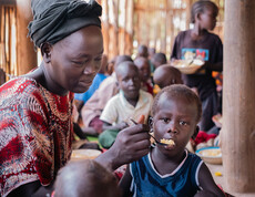 Eine Betreuerin füttert ein Kind in einem Ernährungszentrum im Südsudan.