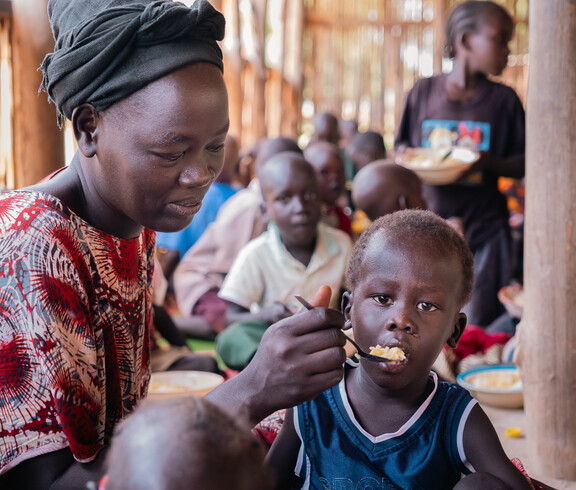 Eine Betreuerin füttert ein Kind in einem Ernährungszentrum im Südsudan.