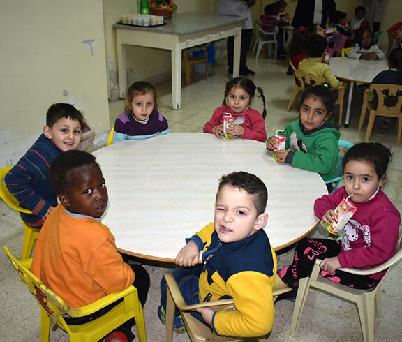 Eine Gruppe Kinder sitzt an einem Esstisch