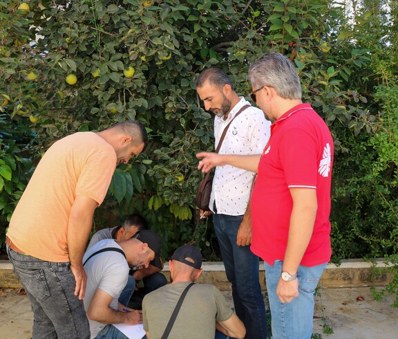 Teilnehmer untersuchen Pflanzen im Rahmen eines praktischen KAMEH-Feldtrainings in Tartous