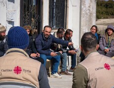 Diskussionsrunde zwischen Landwirt*innen und Caritas-Mitarbeitern vor einem Haus in Deir Touma
