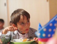 Portrait eines Jungen in einem Kindergarten, der eine Gemüsesuppe ist.